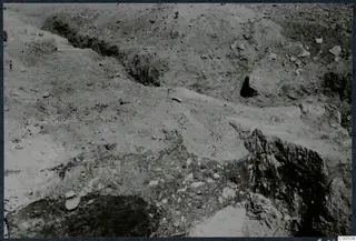 Excavated ground at Vouni with exposed stones and a cut trench running across the slope.
