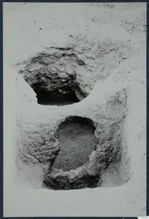 Excavated pale earth face at Vouni with two dark openings, one above the other