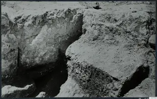 Excavation trench at Vouni with exposed stone walls and cut soil faces.