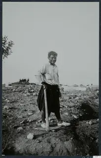 Mavro Keratas smiling and leaning on a pickaxe on an excavated site at Vouni