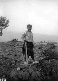 Mavro Keratas smiling and leaning on a hoe on the excavation at Vouni