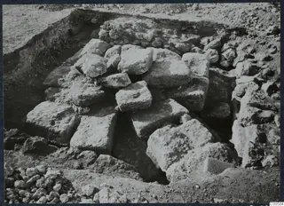 Large squared stone blocks heaped in an excavated pit at Vouni