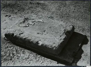 Two rectangular stone blocks lying on dusty ground during excavation at Vouni