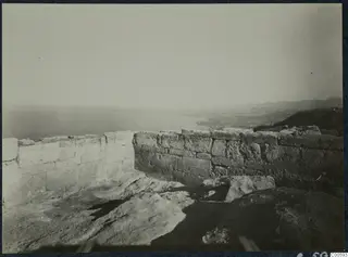 Ashlar walls of the Vouni palace on a rocky height, with the sea and coastal plain beyond.