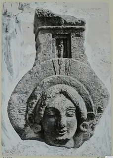Limestone carved head in relief, with a small standing figure in a niche above, from Vouni