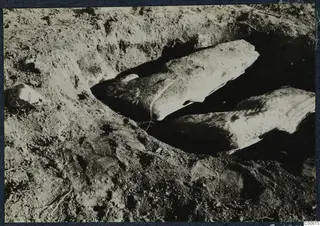 Two large pale stone pieces lying in an excavated trench at Vouni Palace.