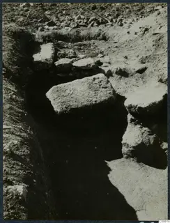 Excavation trench at Vouni with large stone blocks and a peg lying in the soil