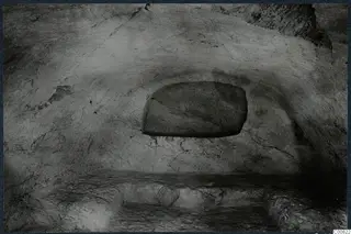 Interior of Tomb 8 at Vouni, showing rock-cut walls, a rectangular recess and a rough ledge along the floor.