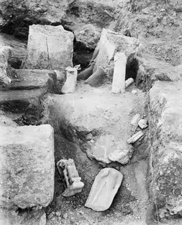 Excavated room at Vouni with statue fragments and column drums lying in situ among stone blocks