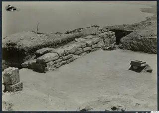 Excavated stone wall at Vouni Palace with a small stone object on a block and the sea beyond