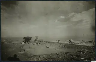 Excavation at the Vouni palace with rails, small wagons and stone walls, with the sea on the horizon