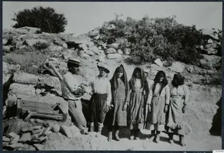 Four women and two men standing in a line in front of a stone wall at Vouni Palace