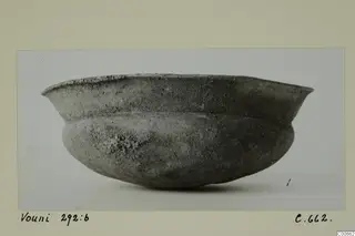 Bowl from Vouni with a flaring rim and rounded body, grey surface with pale encrustation
