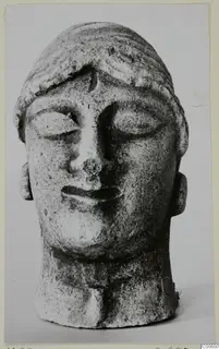 Limestone head of a figure with lowered eyes and banded hair, from Vouni.