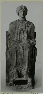Seated figurine with curled hair and a draped garment, on a high-backed seat, from Vouni.