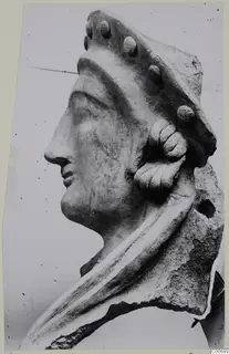 Head in profile facing left, a sculpted head from Vouni with a studded headdress and curled locks over the ear.