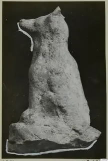Terracotta figurine of a seated animal with upright pointed ears and a long muzzle