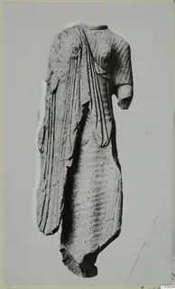 Limestone statue fragment of a draped standing figure from Vouni, head and legs missing, one arm broken short