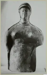 Terracotta bust of a female figure with a close-fitting cap, arms missing, shown against a plain backdrop.
