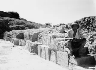 Alfred Westholm seated on the dressed stone facade of the stage at the theatre at Soli