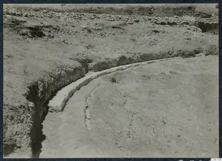Excavation at Soli with a curved row of pale stone blocks running through a trench