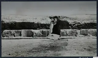 Theatre at Soli: stone wall with a central gap and a wooden frame over the opening, during excavation