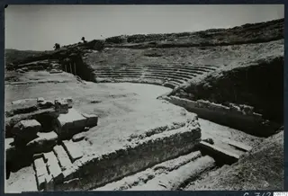 The theatre at Soli, with curved tiers of stone seating behind a paved floor and stone steps in the foreground.