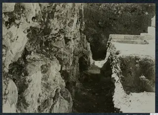 Excavated cutting at the Soli theatre, with a rough rock face on the left and cut stone blocks on the right.