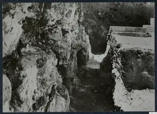 Excavated cutting at the theatre at Soli, with a rock face on the left and cut stone blocks on the right.