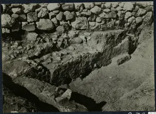 Excavation at Soli showing a stone construction with a rubble stone wall behind it.