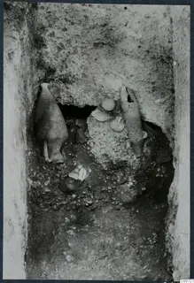 Pottery vessels lying in a narrow rock-cut excavation cutting at Vouni
