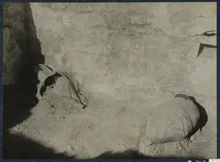 Two large pots lying on the ground at the foot of a plastered wall during excavation at Vouni.