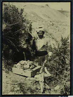 Koundouras preparing meat beside a wooden box on a hillside at Soli