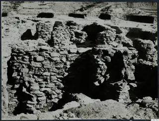 Excavated stone walls and dark openings at Idalion acropolis during excavation