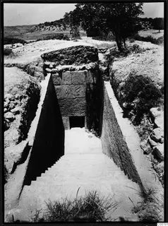 Stepped dromos leading down to the stone-faced entrance of Tomb 1 at Trachonas
