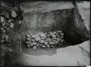 Excavation trench at Plakes, Lapithos, with a heap of stones set against the back face of the cut.