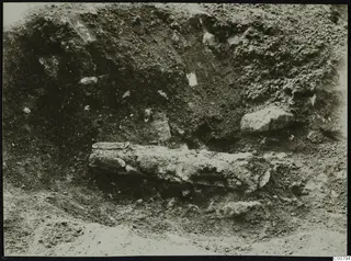 Excavation at Plakes, Lapithos, showing a long object and stones set in the excavated soil
