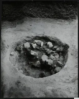 Circular excavation pit at Plakes, Lapithos, with pale stones lying in the soil