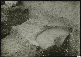 Excavation at Plakes, Lapithos, with a small cardboard box and a stake at the upper left of a cut in the soil.