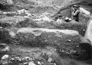 Cross-section of layered soil in a trench at Lapithos, with three men standing at the edge