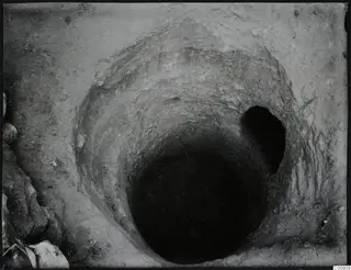 Excavation shaft at Plakes, Lapithos, seen from above, with stones at its edge.