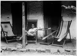 Erik Sjöqvist seated in a striped deck chair on a veranda at Machairas
