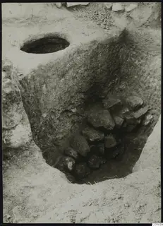 Excavation at Plakes, Lapithos, with a heap of stones filling the lower part of a cut trench.