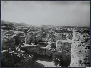 Excavated stone walls and foundations on the Idalion acropolis, with hills beyond.