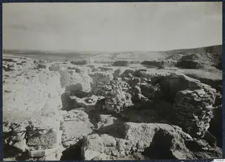 Excavated stone walls and rubble on the Idalion Acropolis, with a plain and hills stretching beyond.