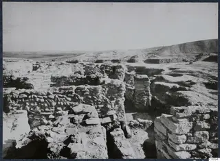 Excavated stone walls on the Acropolis at Idalion, with a bare hill and flat plain behind