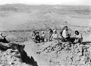 Workers sitting and eating breakfast on the edge of an excavation at Idalion