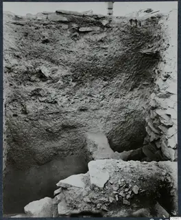 Excavation trench at Idalion acropolis with a soil section, loose stones and flat slabs in the foreground