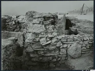 Excavated stone walls at Idalion Acropolis, with a timber frame at the upper right