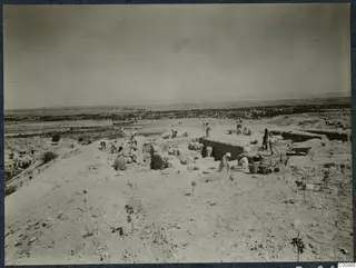 Work in progress at the top of the acropolis at Idalion, with workers digging among low walls.